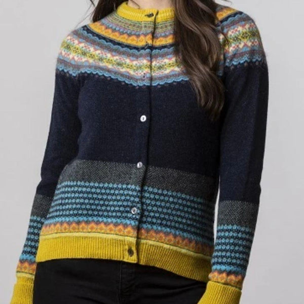 A brunette model wearing a jade colour fairisle sweater with navy, yellow, blue and pink details.