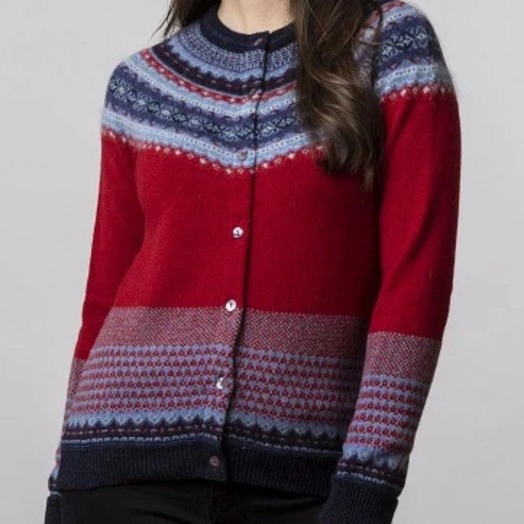 A brunette model wearing a jade colour fairisle sweater with red, navy, purple and grey details.